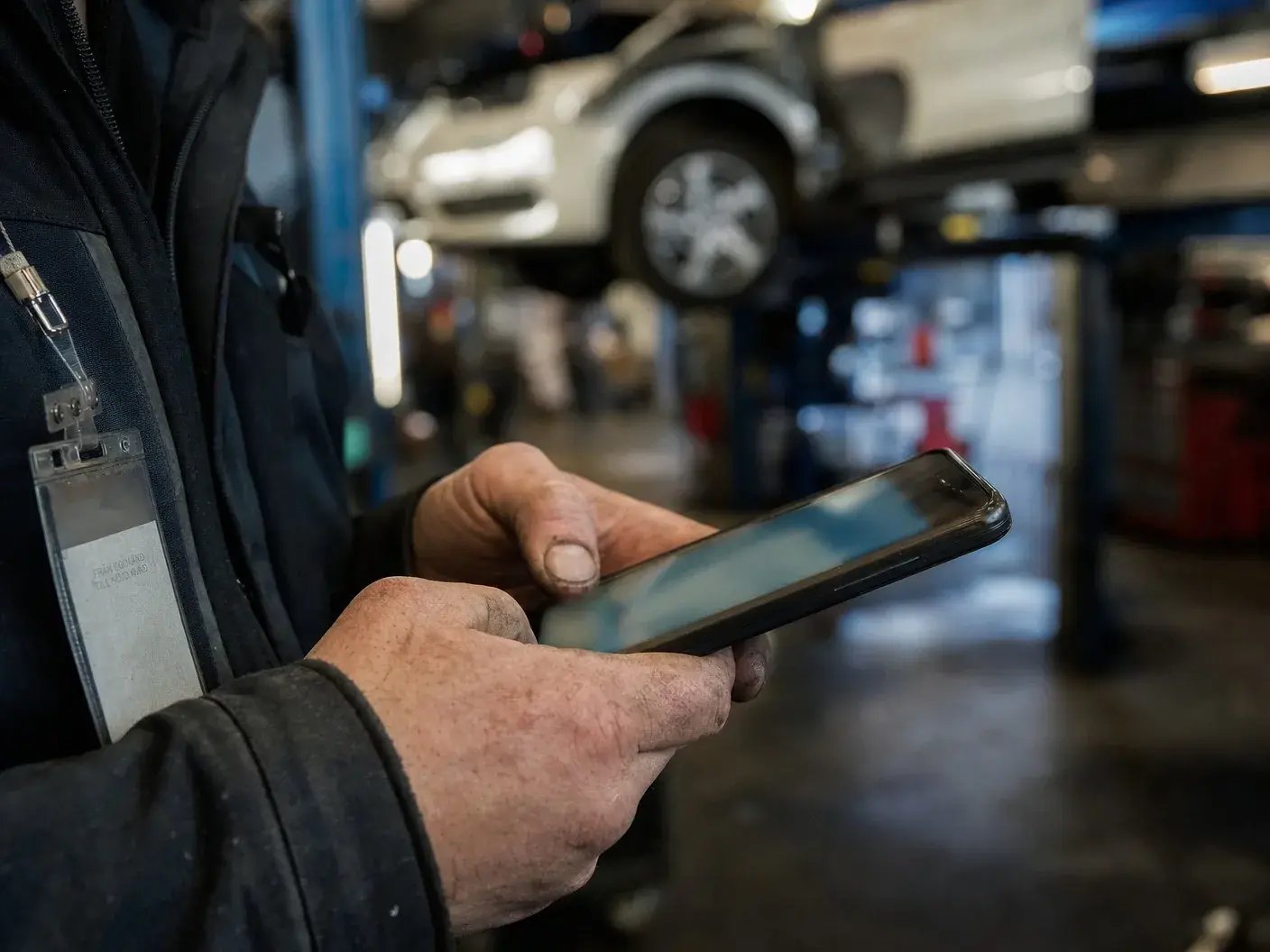 Närbild på en medarbetares händer och mobiltelefon