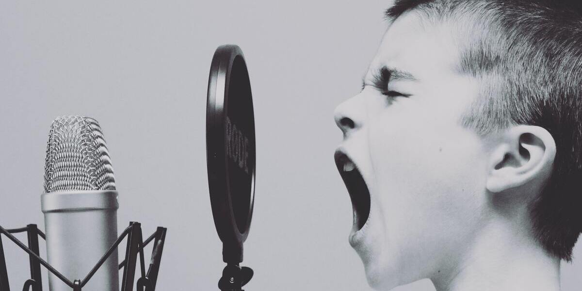 Barn som skriker eller sjunger in i en mikrofon.